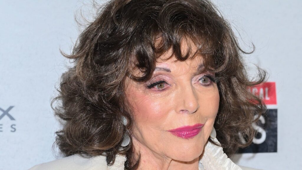 Dame Joan Collins 92 is a doting godmother in most incredible caped dress